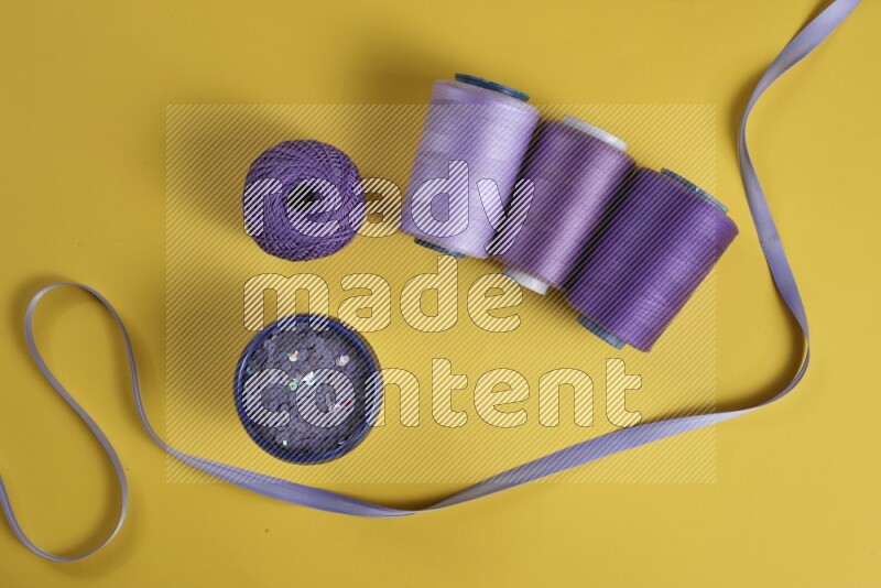 A purple collection of sewing and tailoring tools arranged on a yellow background