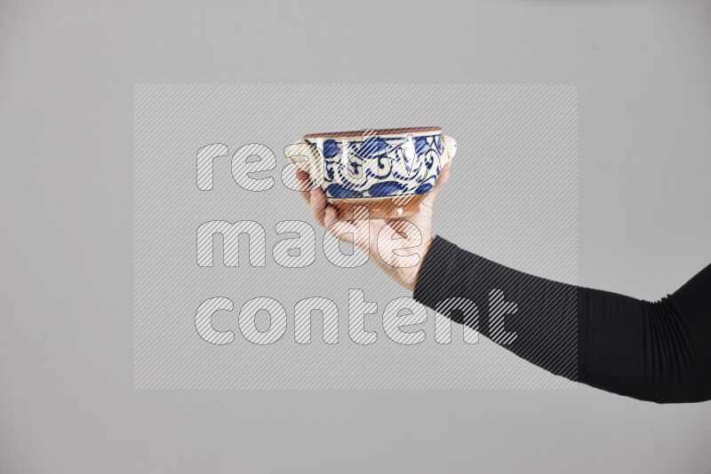 A woman in black abaya holding different pottery essentials in different positions