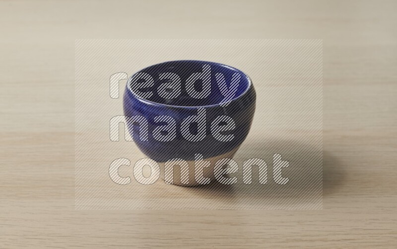 وعاء فخاري متعدد الألوان على خلفية خشبية فاتحة