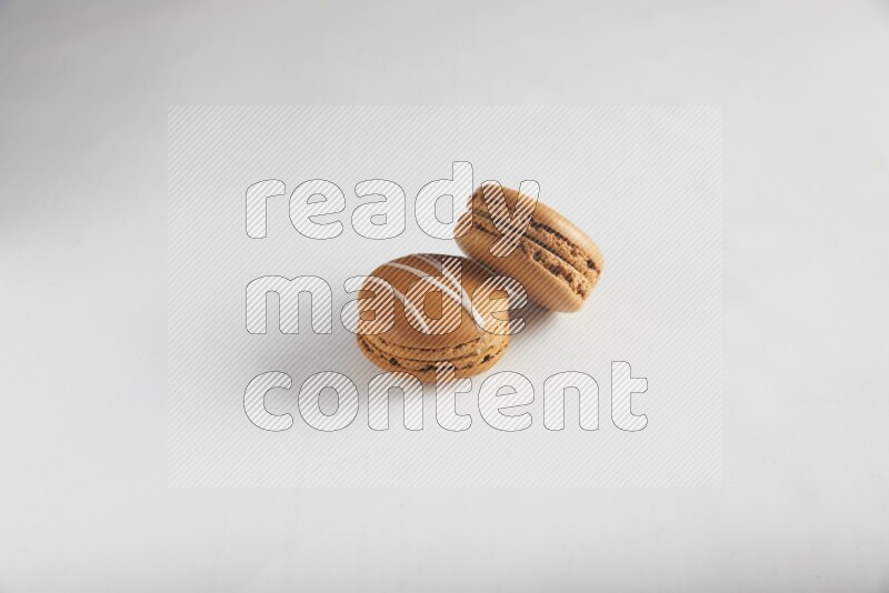 45º Shot of of two assorted Brown Irish Cream, and Brown Maple Taffy macarons  on white background