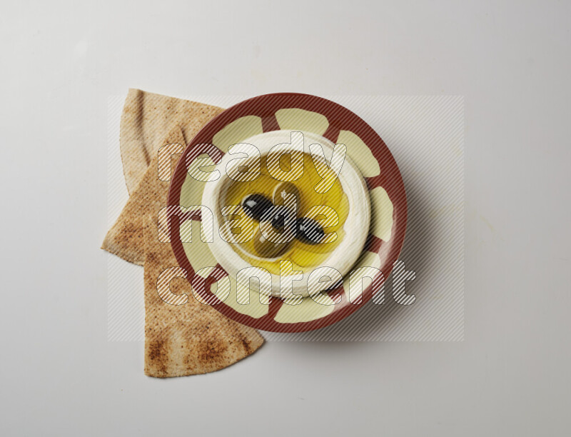 Lebnah garnished with olives in a traditional plate on a white background