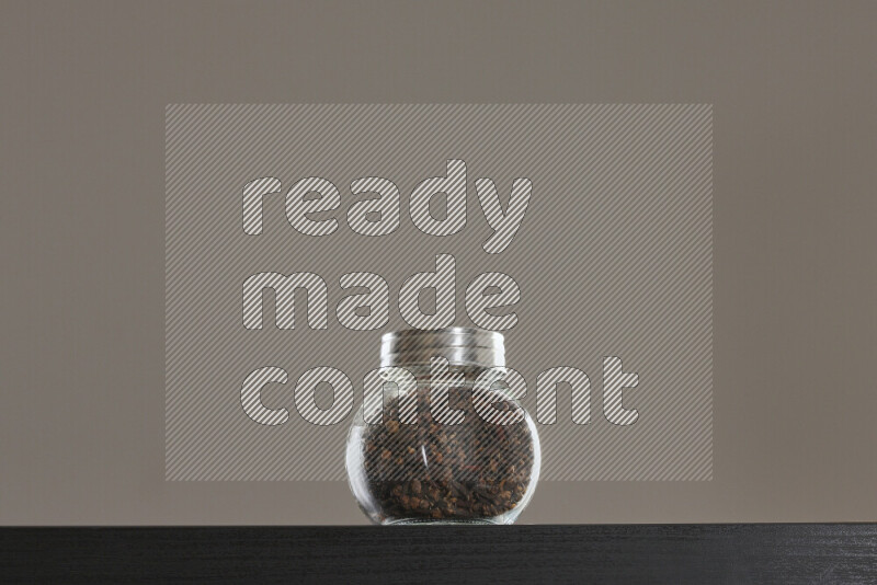 قرنفل في وعاء زجاجي على خلفية سوداء