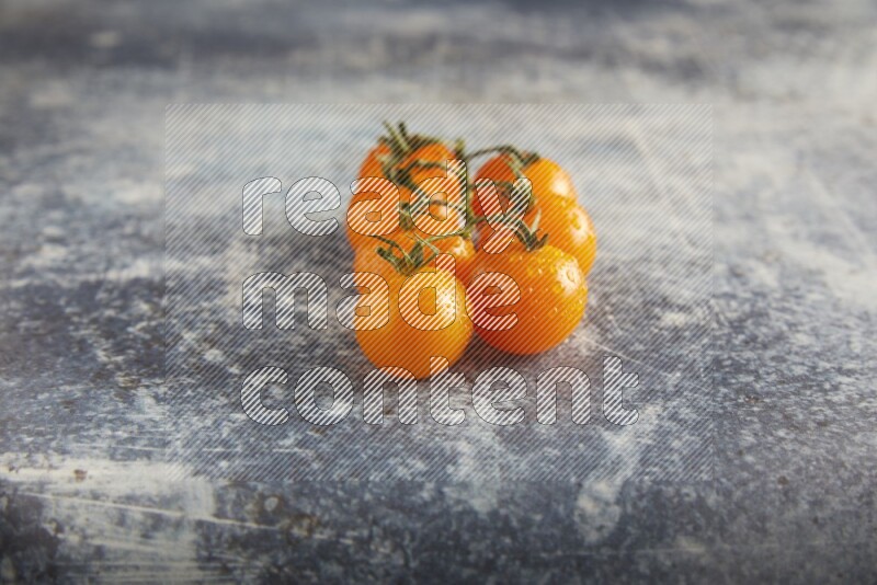 Orange cherry tomato vein on a textured rusty blue background 45 degree