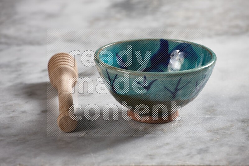 Decorative pottery bowl with wooden honey dipper on the side on grey marble background