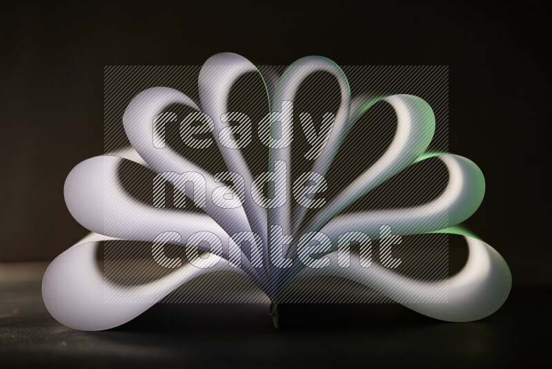 An abstract art piece displaying smooth curves in green and white gradients created by colored light