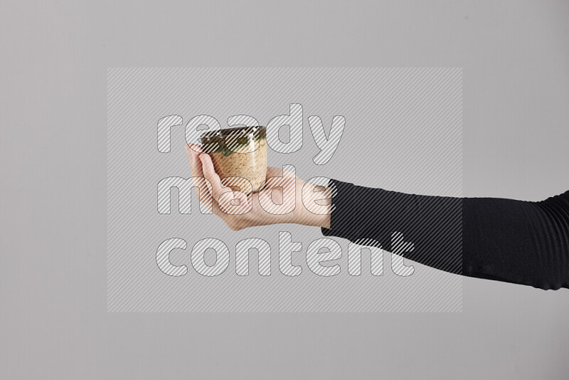 A woman in black abaya holding different pottery essentials in different positions