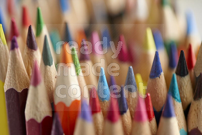 The image captures a close-up of sharpened colored pencils on multicolored background