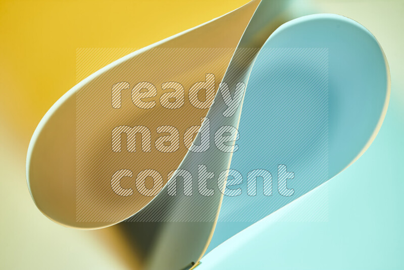 An abstract art of paper folded into smooth curves in blue and yellow gradients