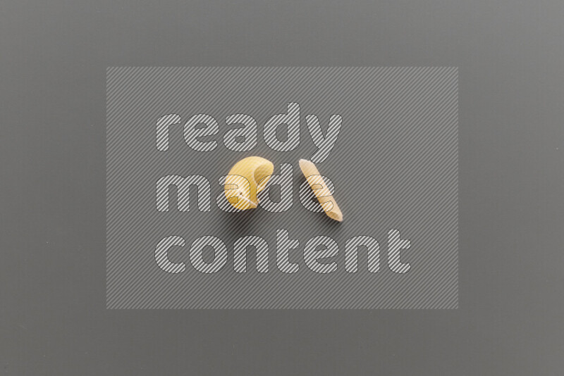 Pipe pasta with other types of pasta on grey background