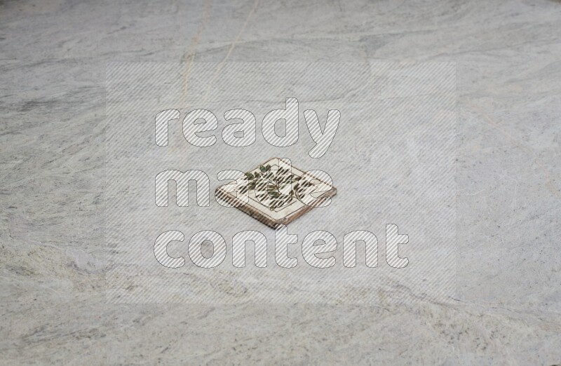 Top view shot of a pottery coaster\ tile on beige marble flooring