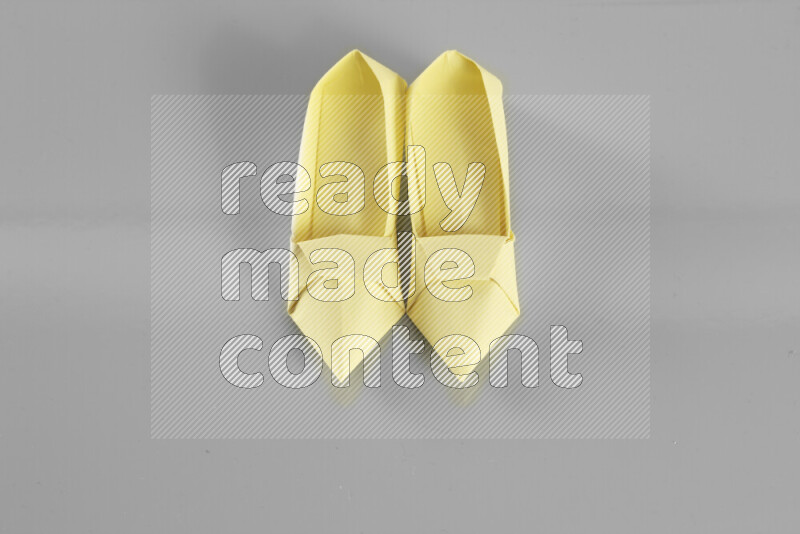 Origami shoes on grey background