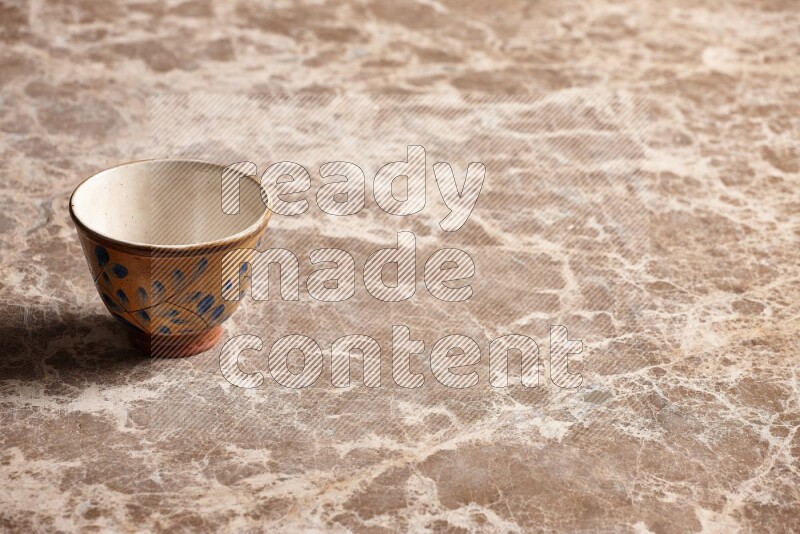 A decorative pottery bowl on beige marble background