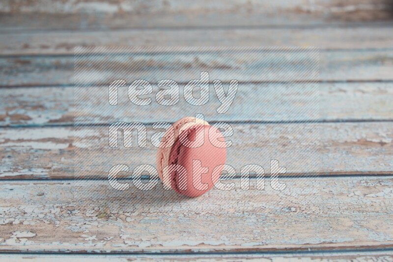 45º Shot of Pink Litchi Raspberry macaron on light blue wooden background