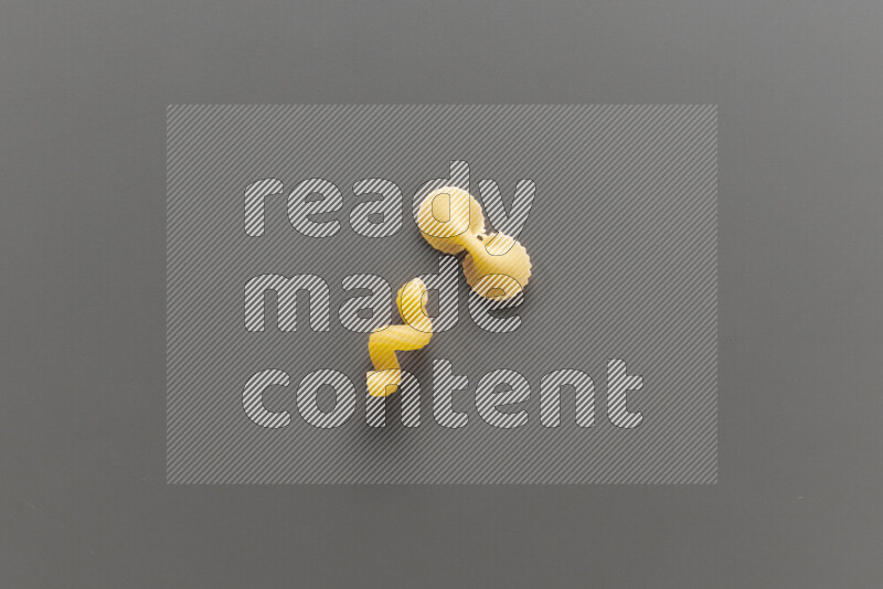 Twist pasta with other types of pasta on grey background