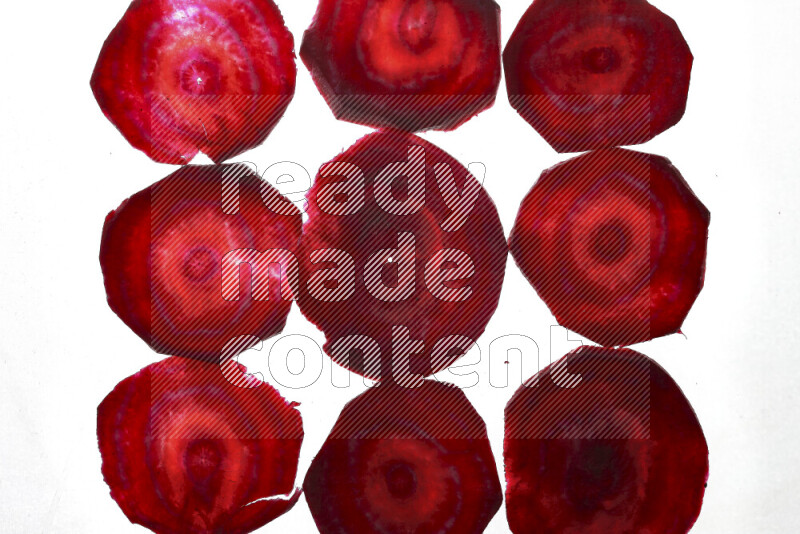 Beet slices on illuminated white background