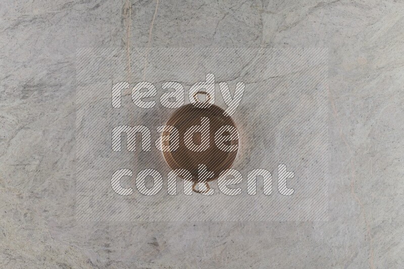 A small copper pan on grey marble background