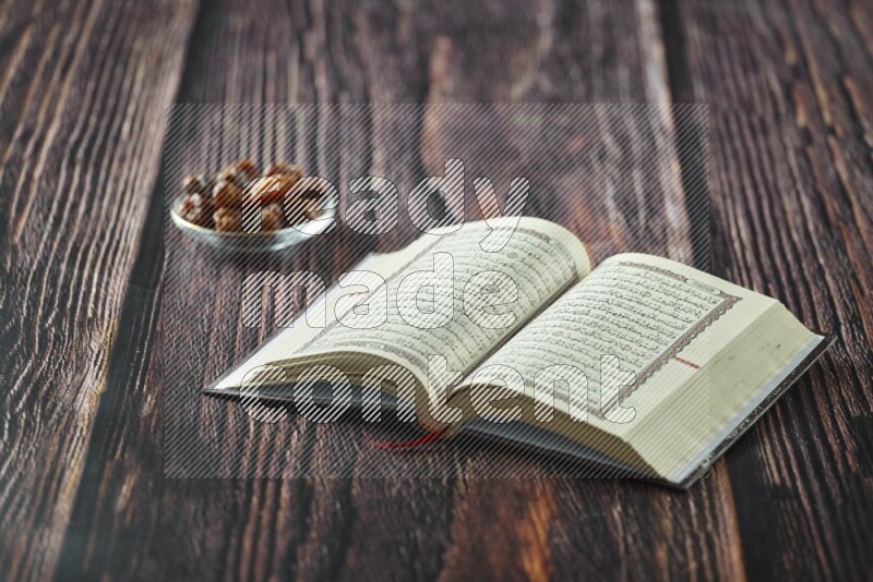 Quran with dates, prayer beads and different drinks all placed on wooden background