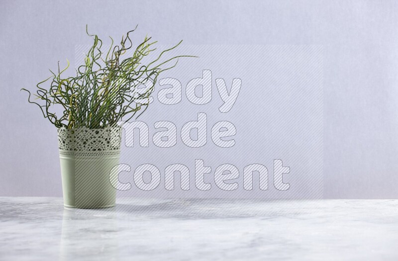 Artificial plant in green decorative pot on grey marble background