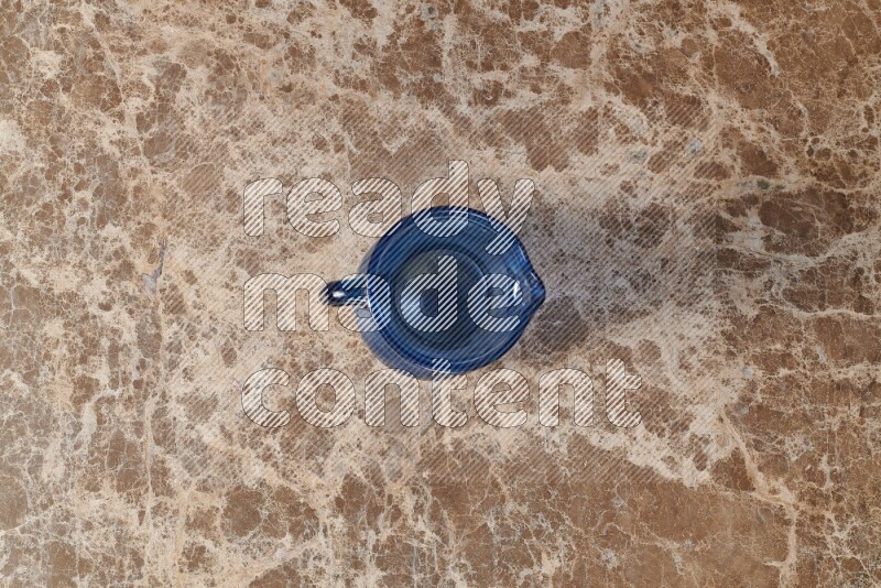 A colored glass jug on beige marble background