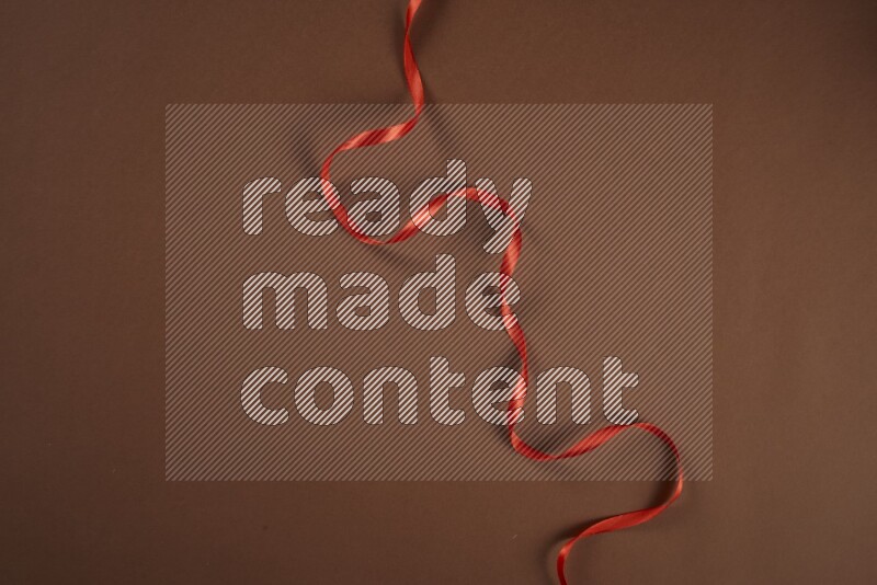 مجموعة من أدوات الخياطة والتفصيل حمراء اللون على خلفية بنية