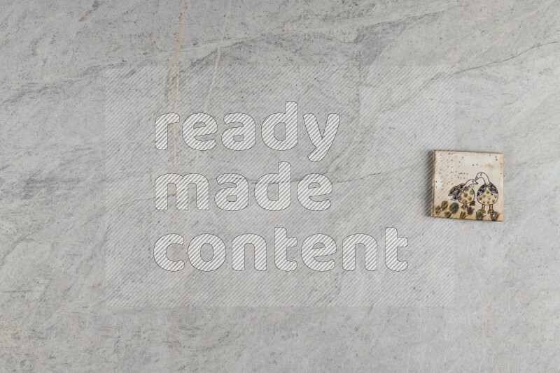 A decorative pottery coaster on grey marble background