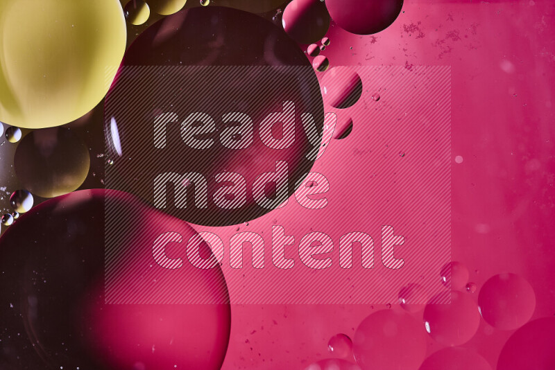 Close-ups of abstract oil bubbles on water surface in shades of yellow and pink