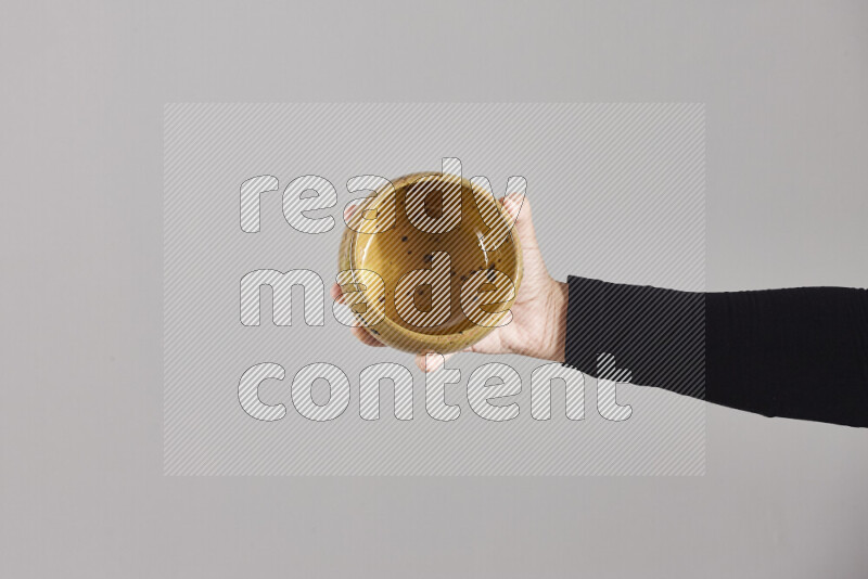 A woman in black abaya holding different pottery essentials in different positions