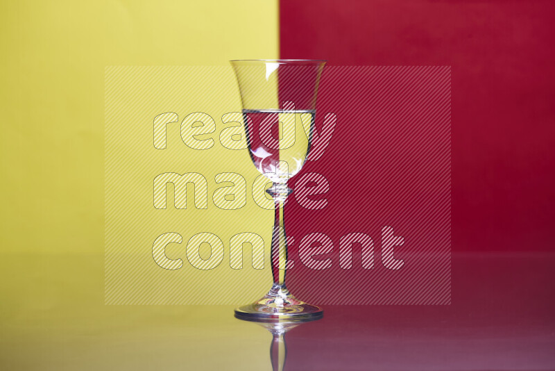 The image features a clear glassware filled with water, set against yellow and red background