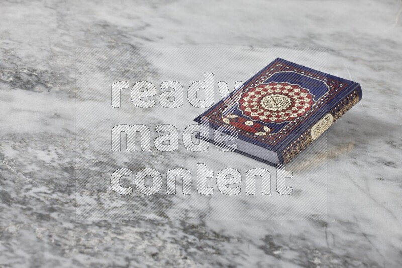 Quran with a prayer beads on grey marble background