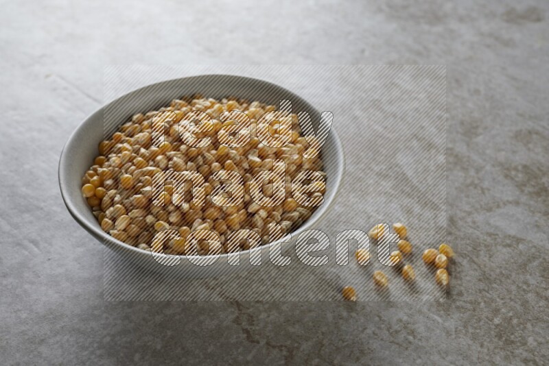 corn kernel in a gray ceramic bowl on a grey textured countertop