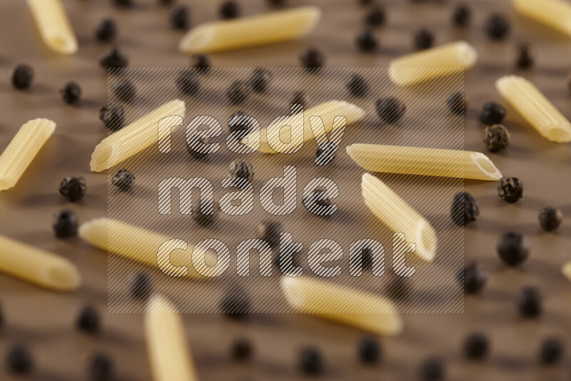 معكرونة مع مكونات متنوعة من الطماطم والثوم والبصل والفلفل الأحمر والفلفل الأسود والفلفل الأبيض وأوراق الغار وإكليل الجبل والهيل على خلفية بيج