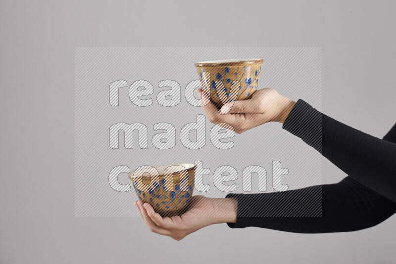 A woman in black abaya holding different pottery essentials in different positions