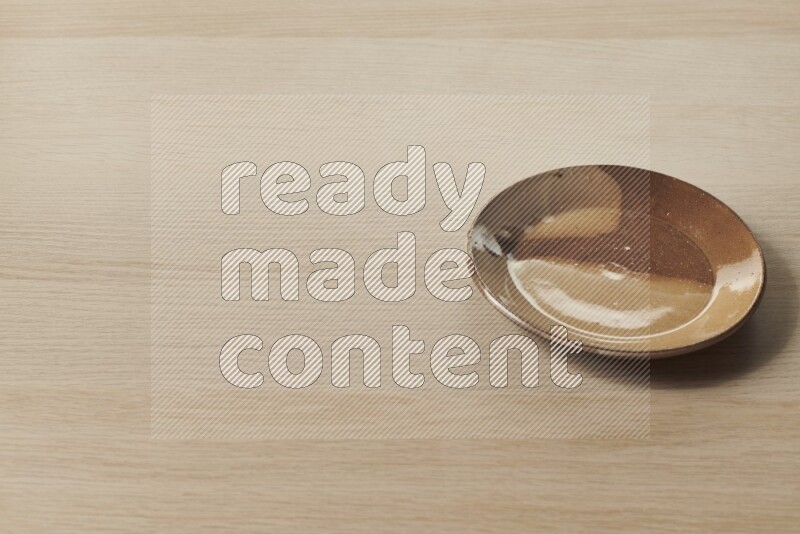 صحن فخاري متعدد الألوان على خلفية خشبية فاتحة