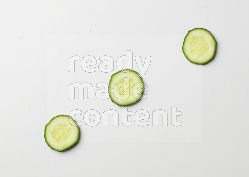 three cucumber slices on white background