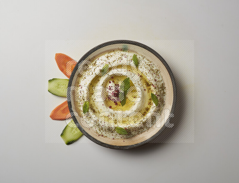 Lebnah garnished with zaater, mint & sumak in a pottery plate on a white background