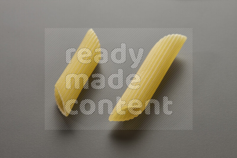 Penne pasta on grey background