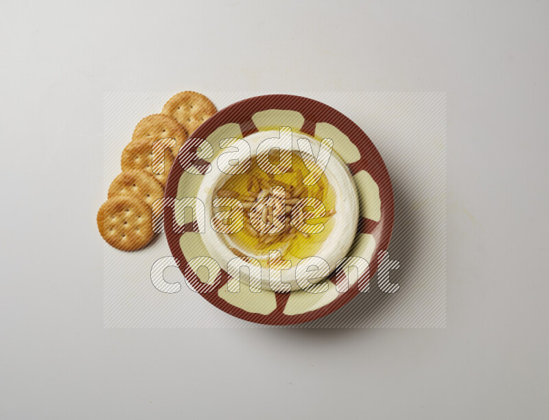 Lebnah garnished with pine nuts in a traditional plate on a white background