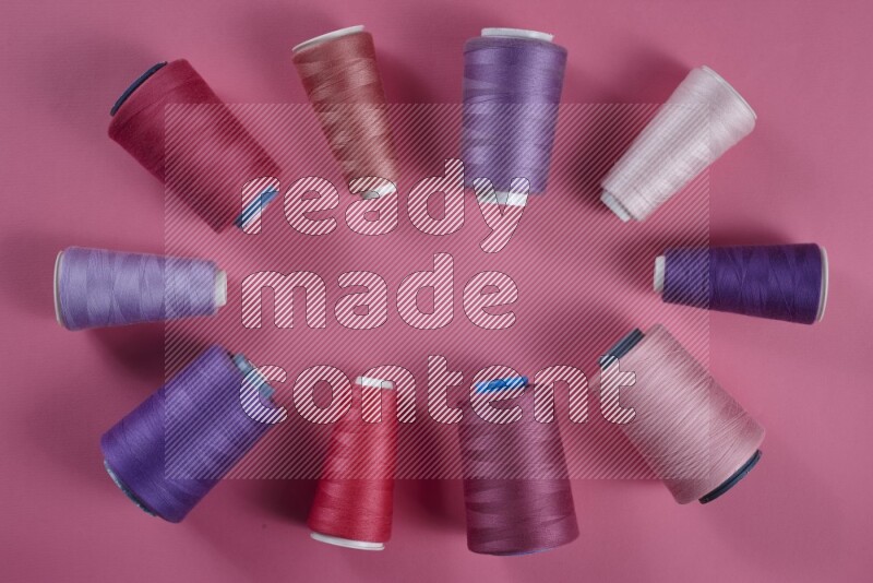 مجموعة من أدوات الخياطة والتفصيل أرجوانية وزهرية اللون على خلفية زهرية