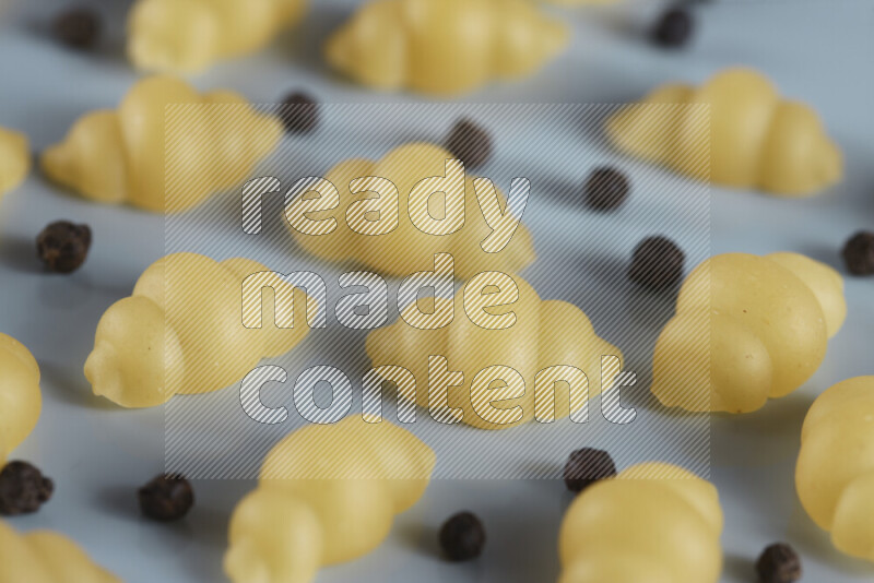 معكرونة مع مكونات متنوعة من الطماطم والثوم والبصل والفلفل الأحمر والفلفل الأسود والفلفل الأبيض وأوراق الغار وإكليل الجبل والهيل و مشروم على خلفية زرقاء فاتحة