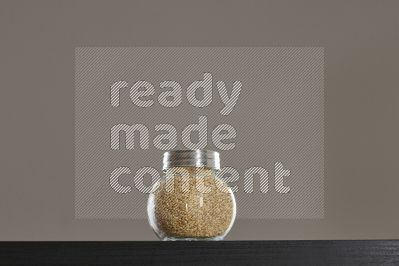 Sesame in a glass jar on black background