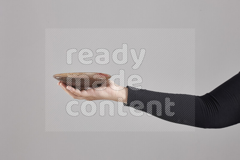 A woman in black abaya holding different pottery essentials in different positions
