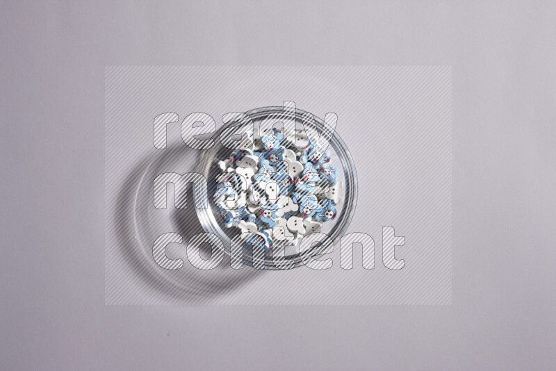 Colored buttons in a glass bowl on grey background