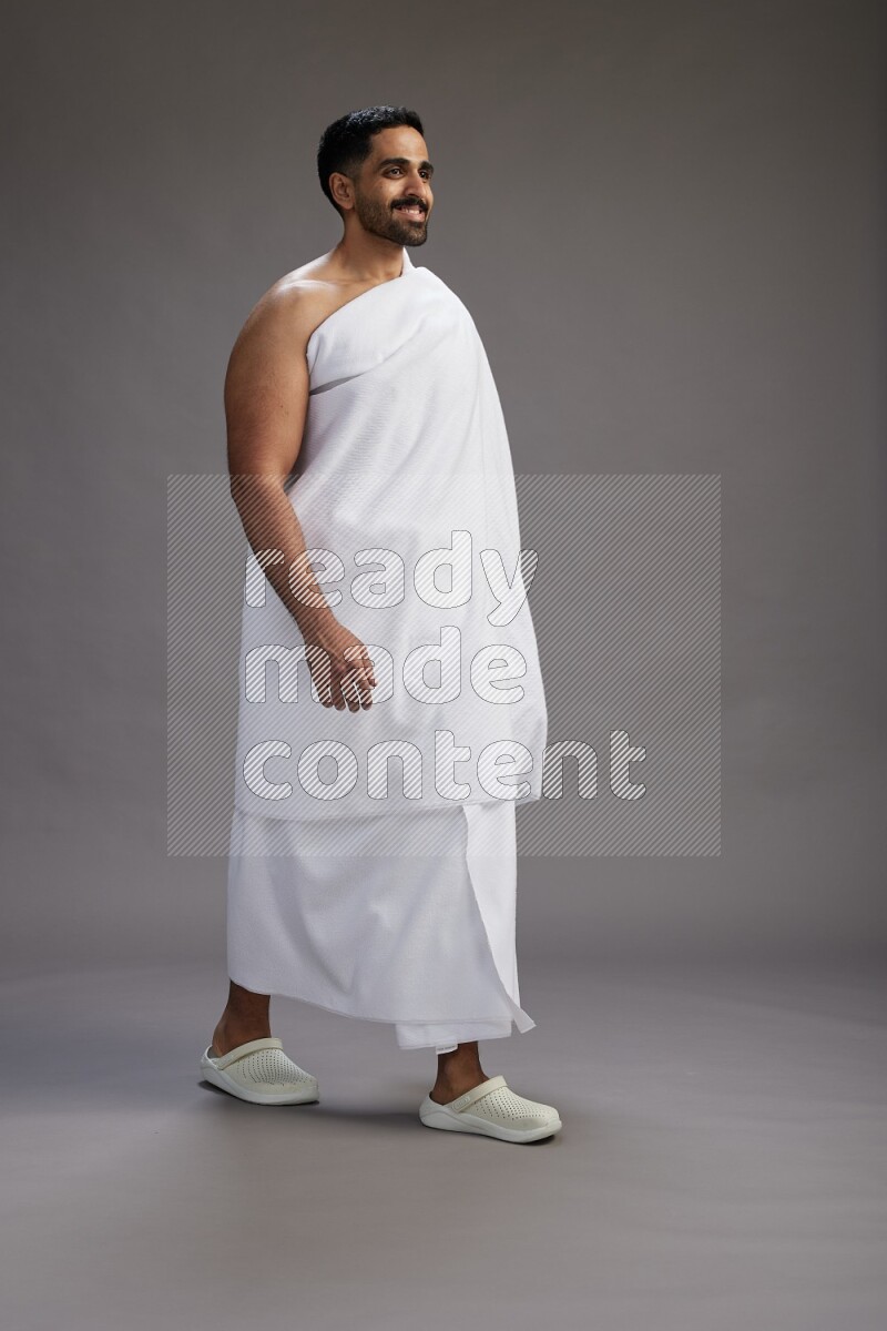 A man wearing Ehram Standing Interacting with the camera on gray background