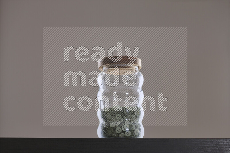 Buttons in a glass jar on black background