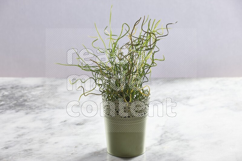 Artificial plant in green decorative pot on grey marble background