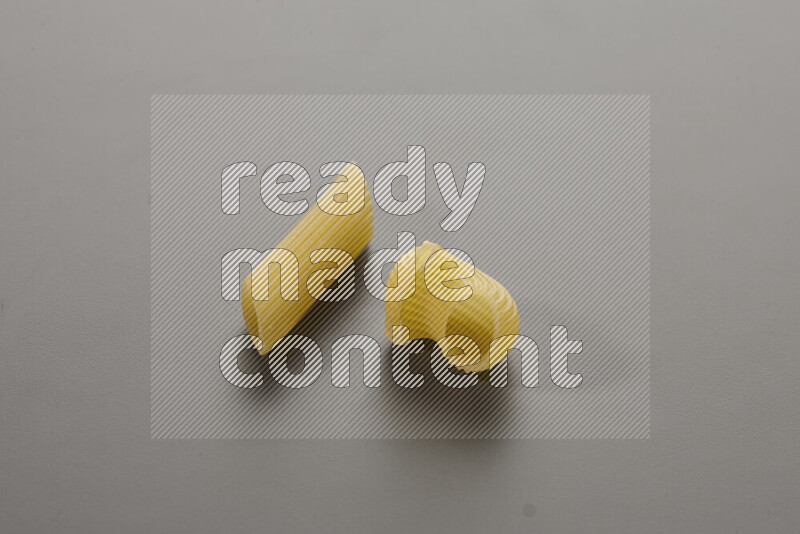 Penne pasta with other types of pasta on grey background