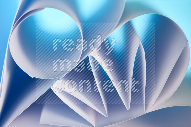 An artistic display of paper folds creating a harmonious blend of geometric shapes, highlighted by soft lighting in blue and white tones