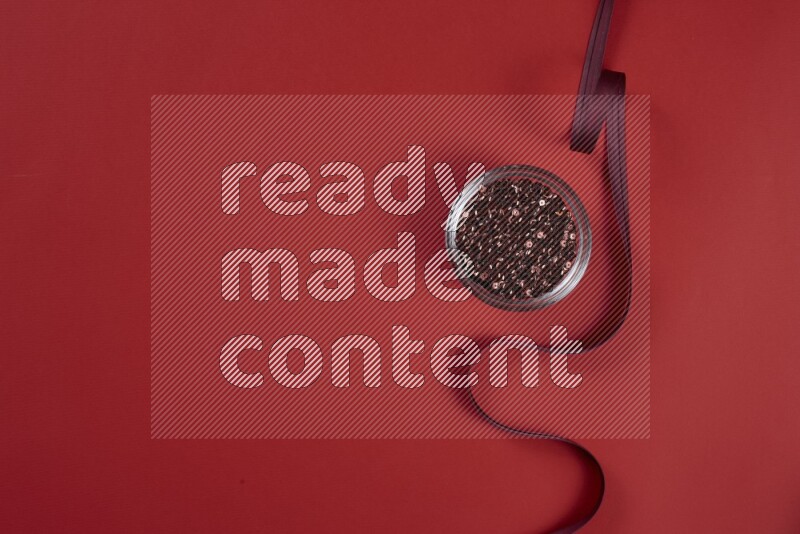 A red collection of sewing and tailoring tools arranged on a red background