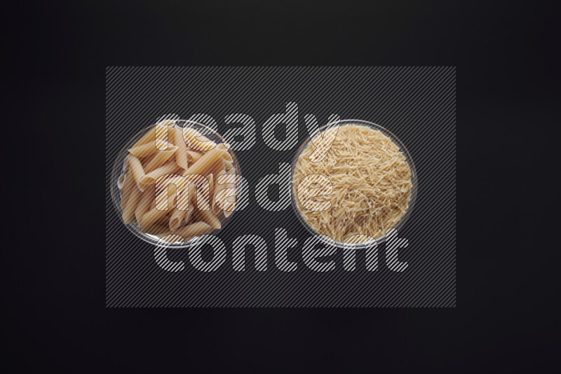 Different pasta types in glass bowls on black background