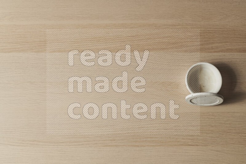 A white pottery bowl on light wooden background